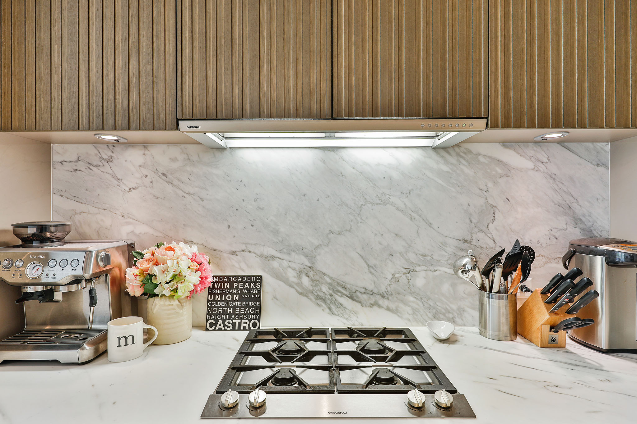 Gaggenau appliances, ArcLinea cabinetry with white marble counter & island