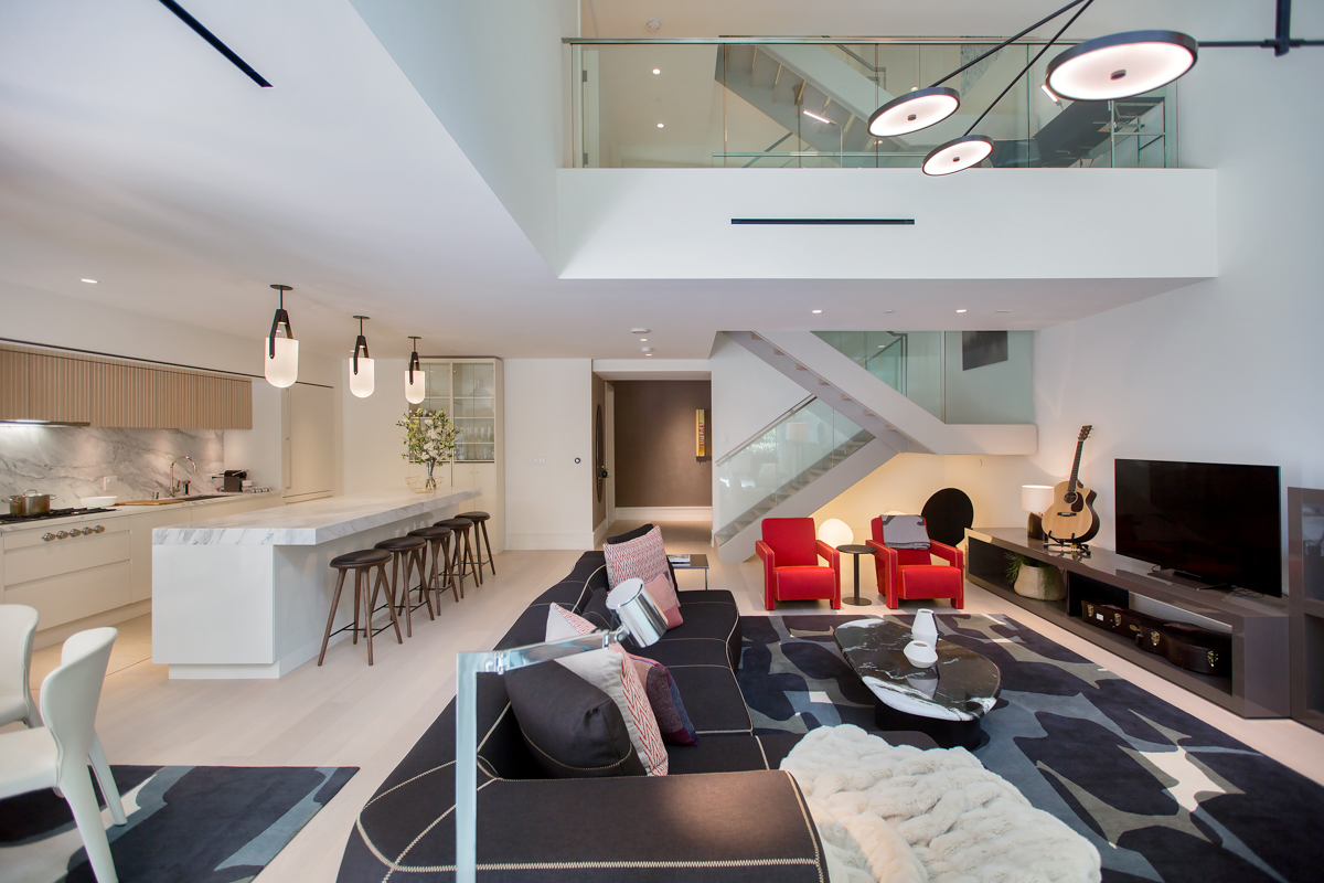 Living room and kitchen facing open staircase