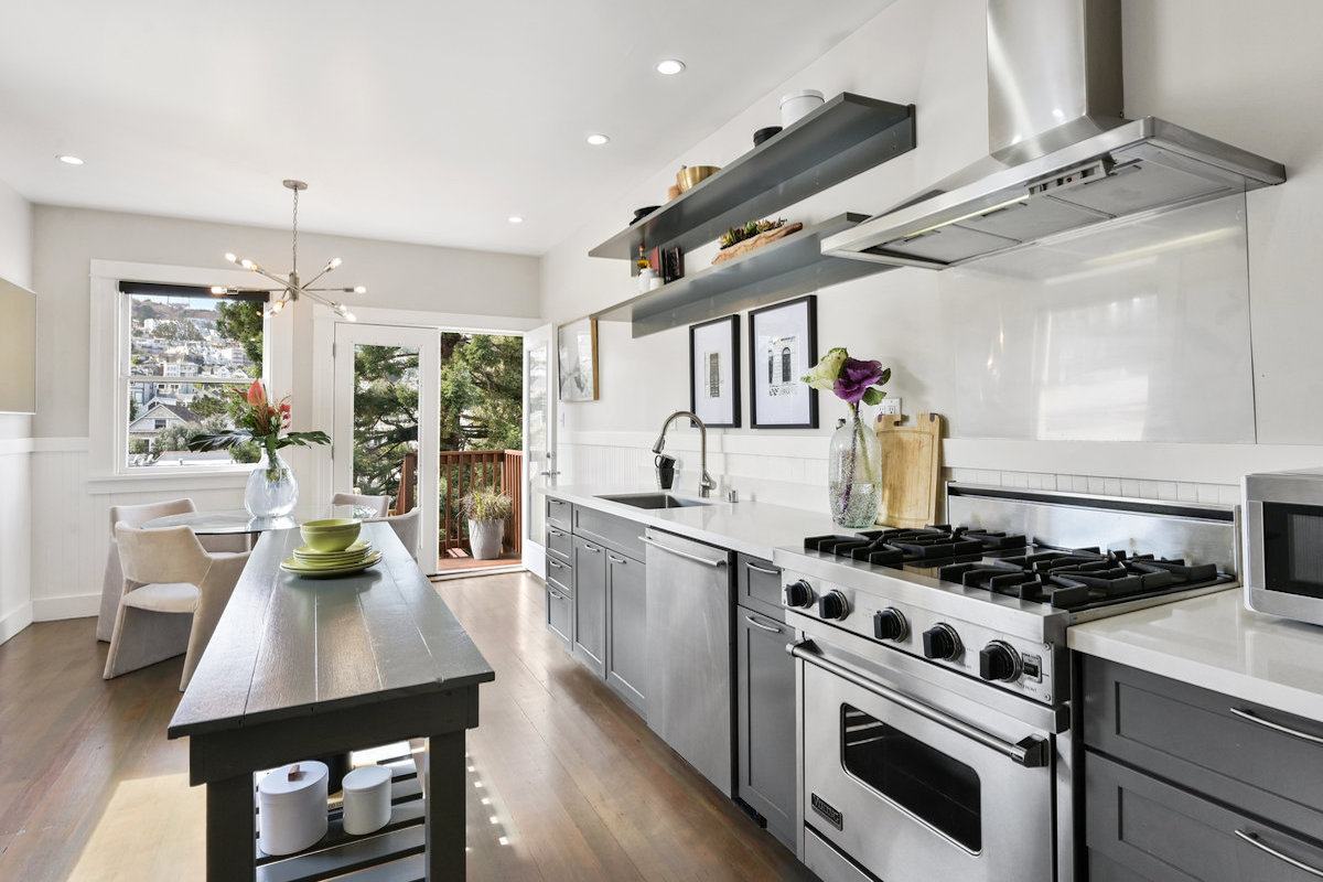 Kitchen leads to dining area and outdoor seating with western views.