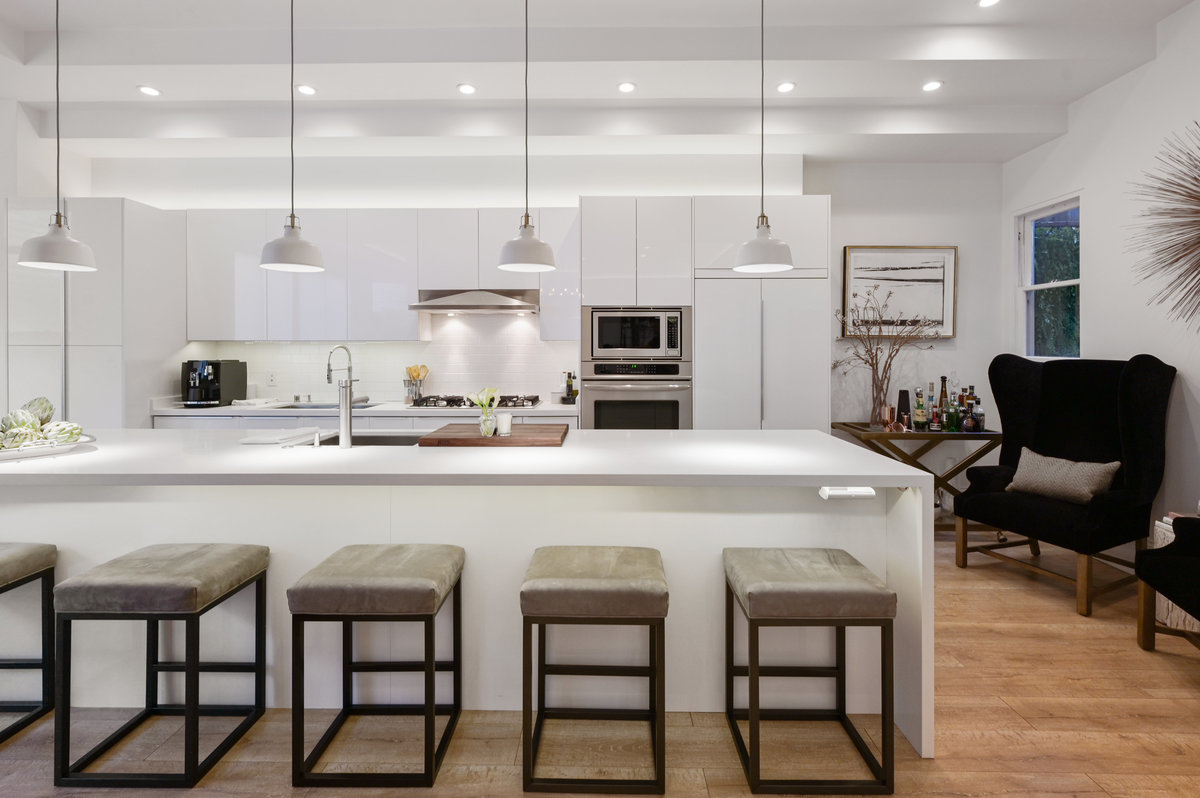 Chef's gas kitchen with high gloss white cabinetry, quartzite island and top of the line appliances
