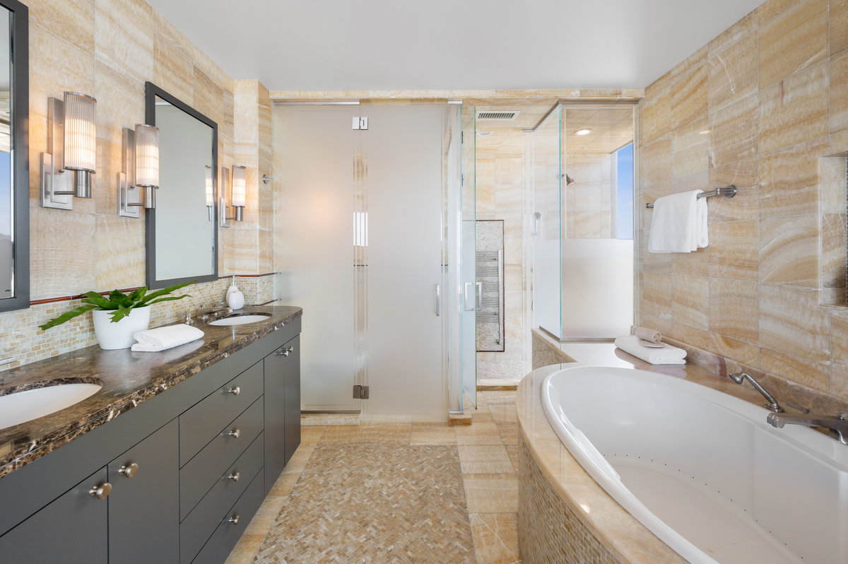 Primary bath's onyx and marble finishes includes shower with view, private WC, dual sinks and large tub