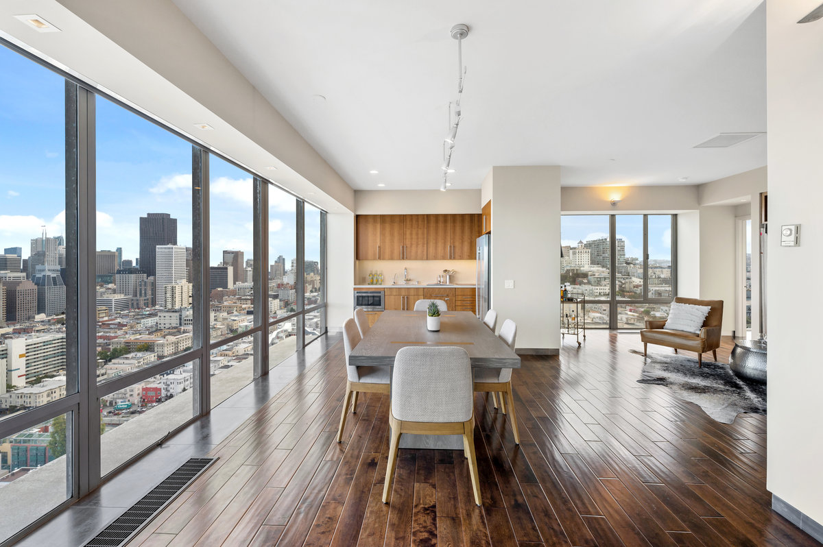 Dining area and streamlined kitchen; den on right with downtown views
