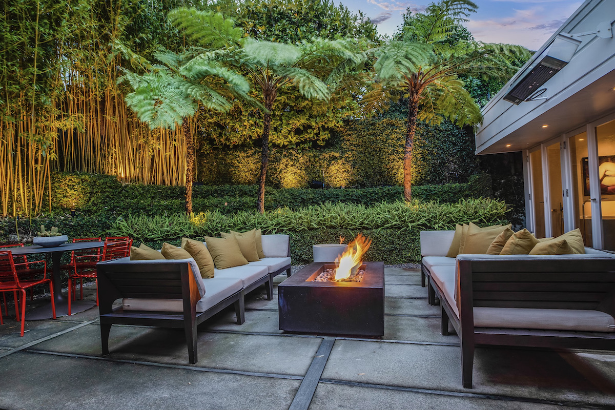 Rear patio and garden with seating and firepit at twilight