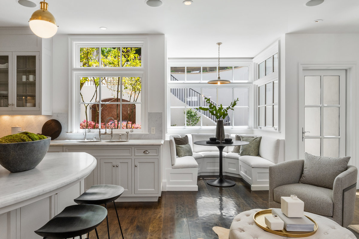 Gorgeous chef's kitchen with banquette, island, three sinks, extra seating by fireplace