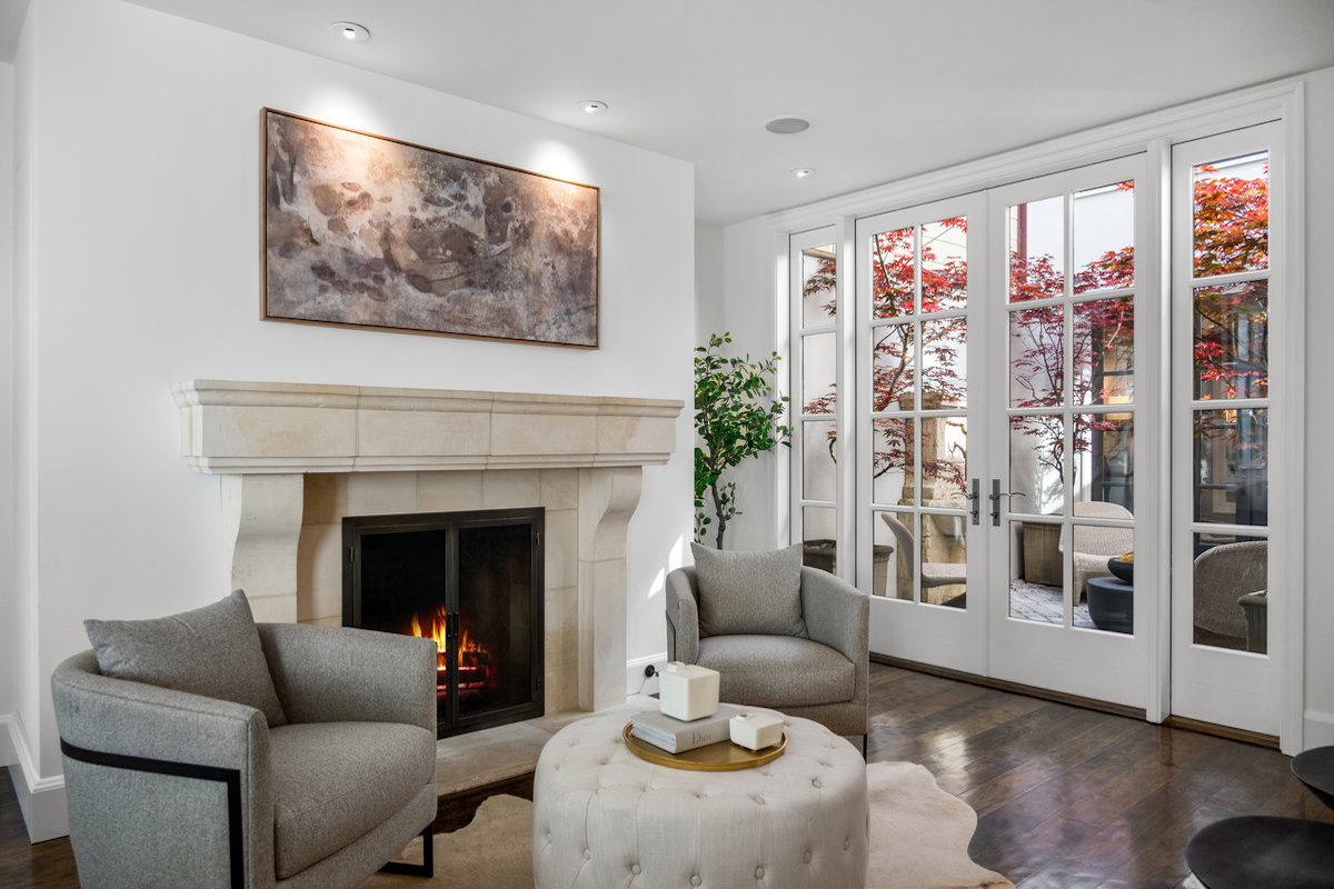 Kitchen seating area with fireplace also opens to center patio; TV connections behind artwork