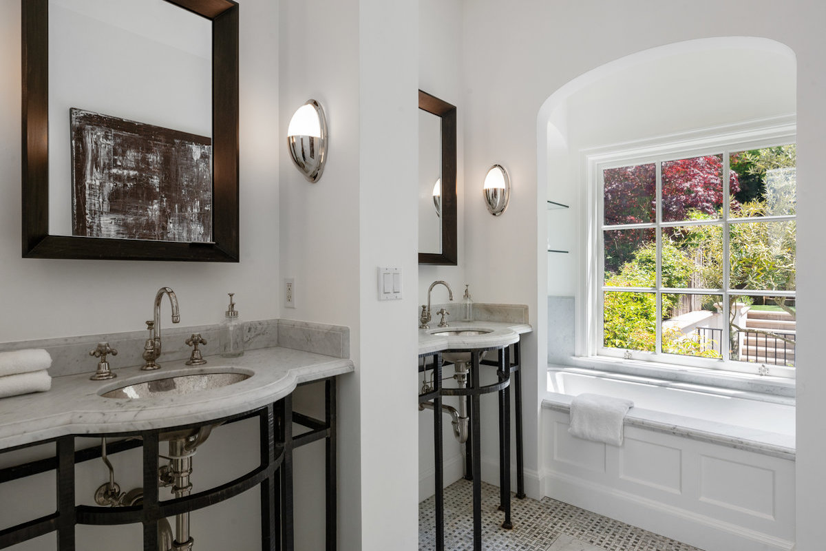 Marble primary bath with dual vanities, tub, shower stall with skylight, separate water closet