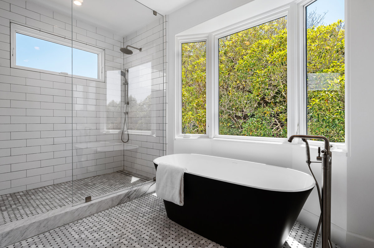 Primary bath with soaking tub and generous shower; outlooks to the south garden