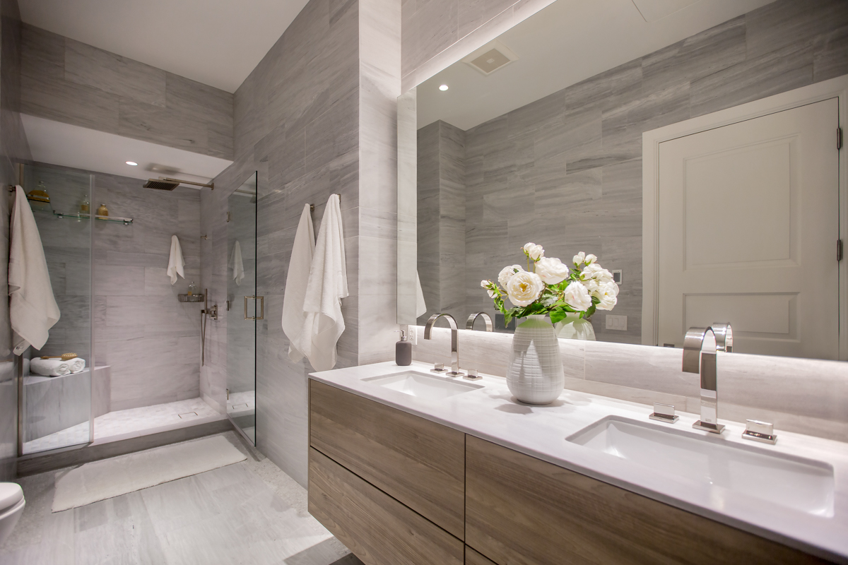 The spa-style bath, clad in soothing grey marble, includes heated floor, dual sinks and stall shower
