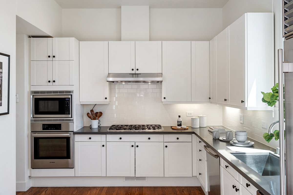 Upgraded kitchen with grey quartz counters and white subway tile backsplash