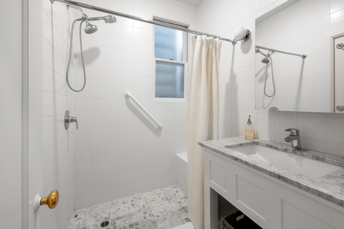 Split bath, shower with seat, marble counter at sink