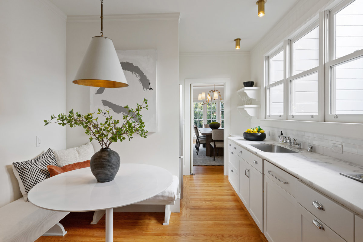 Eating portion of kitchen with windows over marble counter