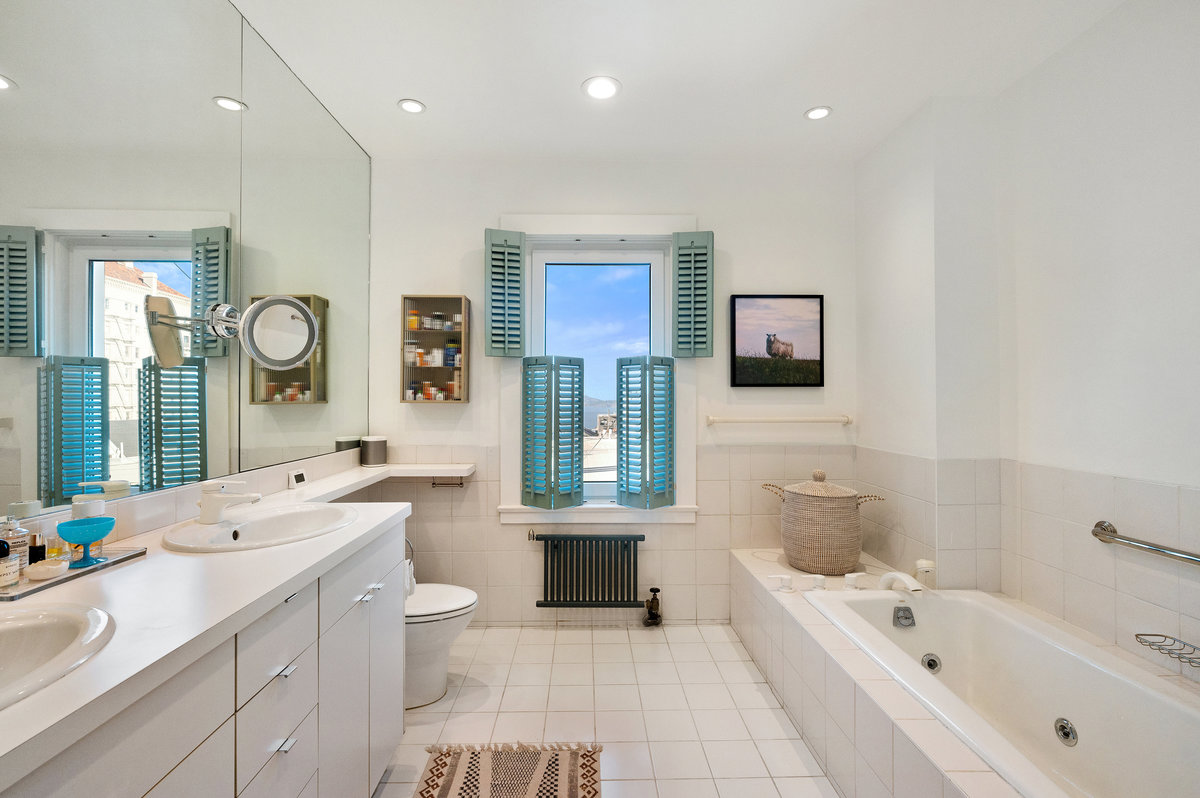 Primary bath with shower, tub, dual sinks, north window with glimpse of Bay