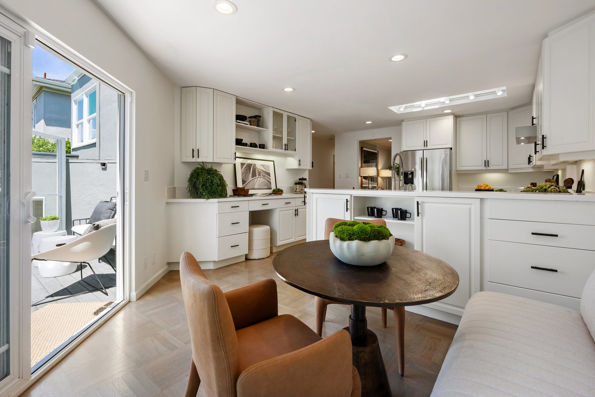 Eat-in area of kitchen, desk, tons of cabinets and door to deck