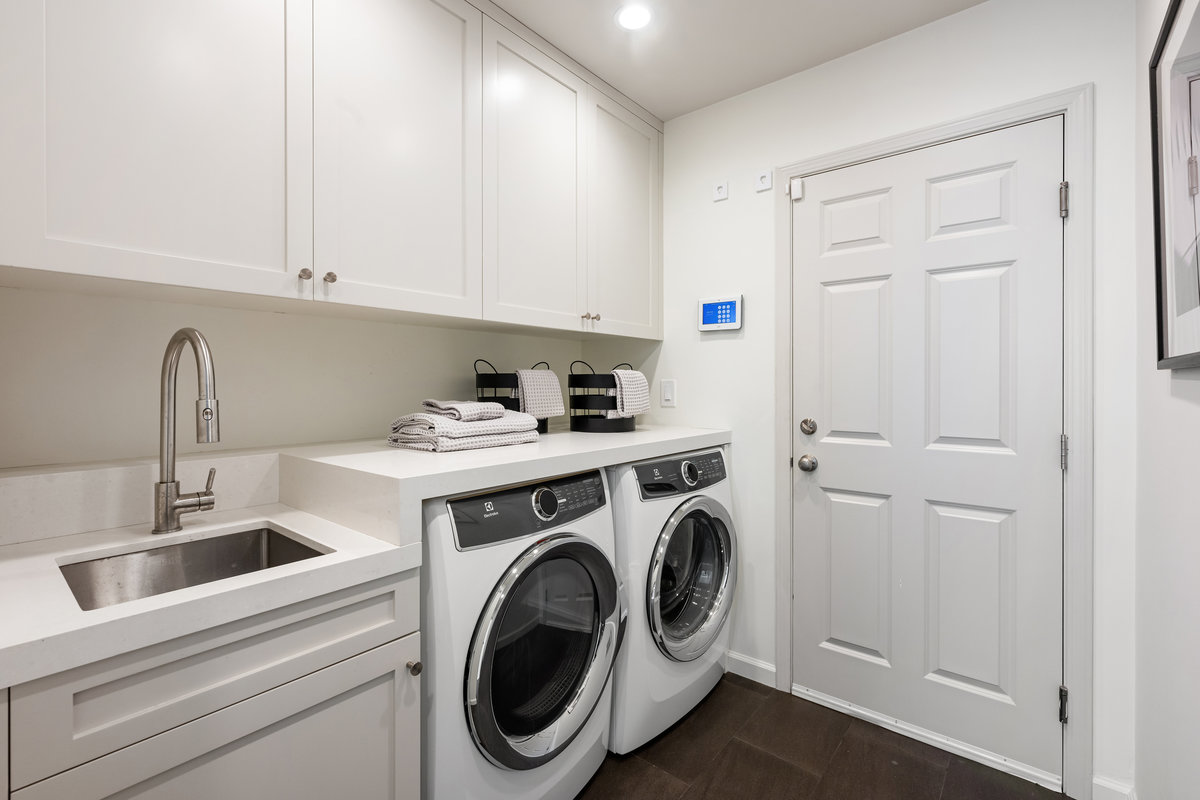 Laundry room with sink and storage; door to garage